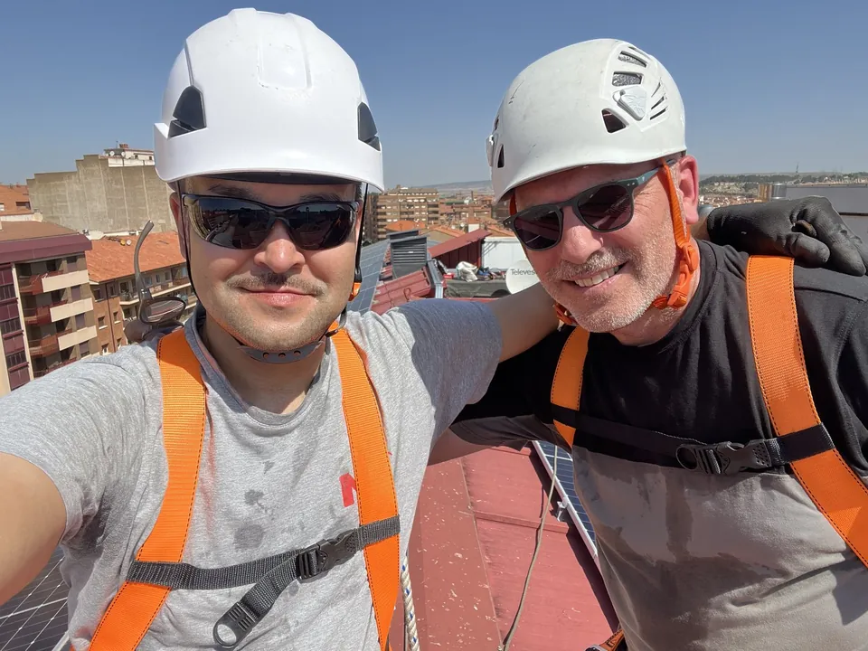 Dos personas del equipo en una cubierta durante un trabajo de instalación solar